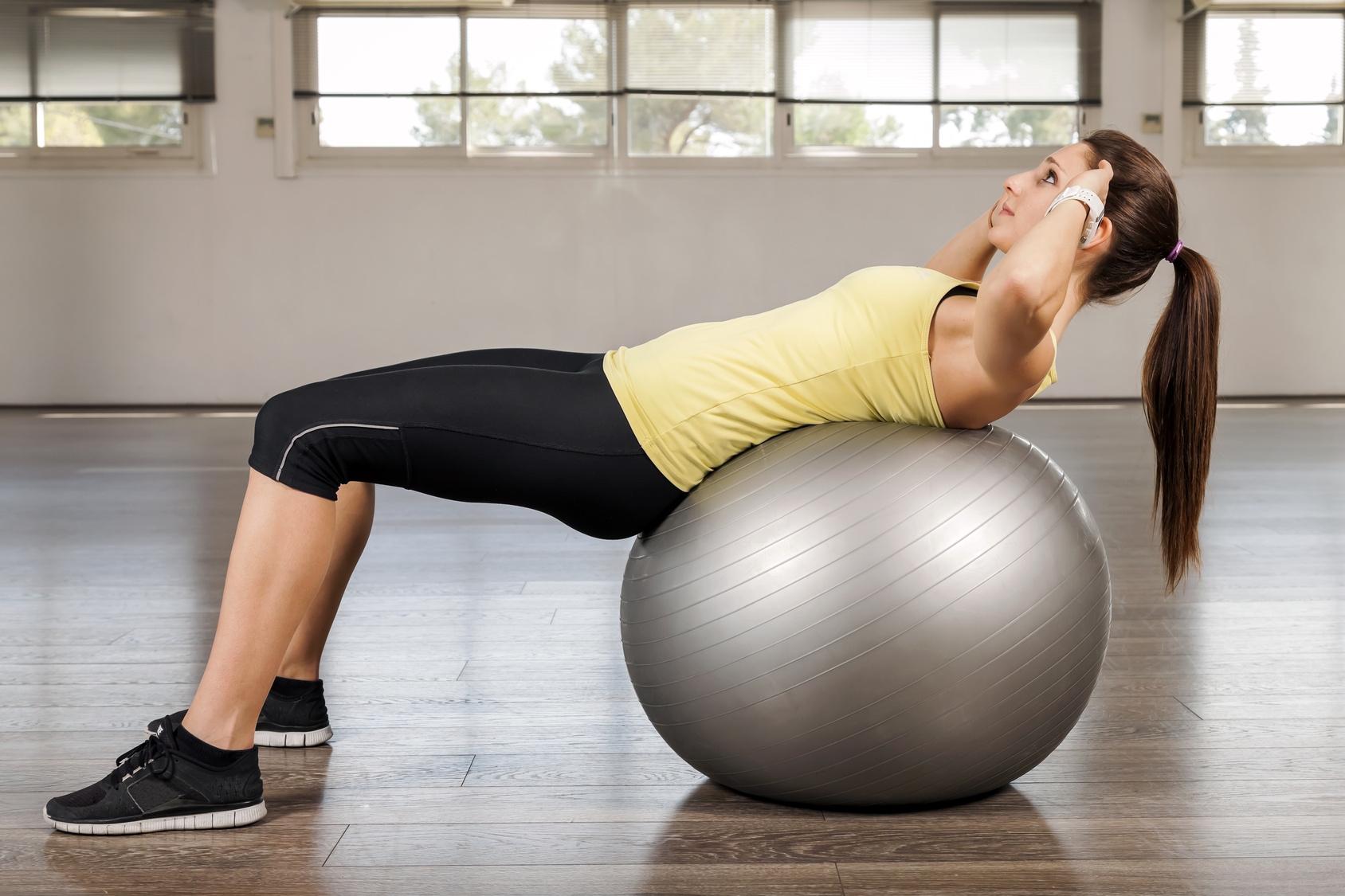 Young woman doing abdominal on a exercise ball